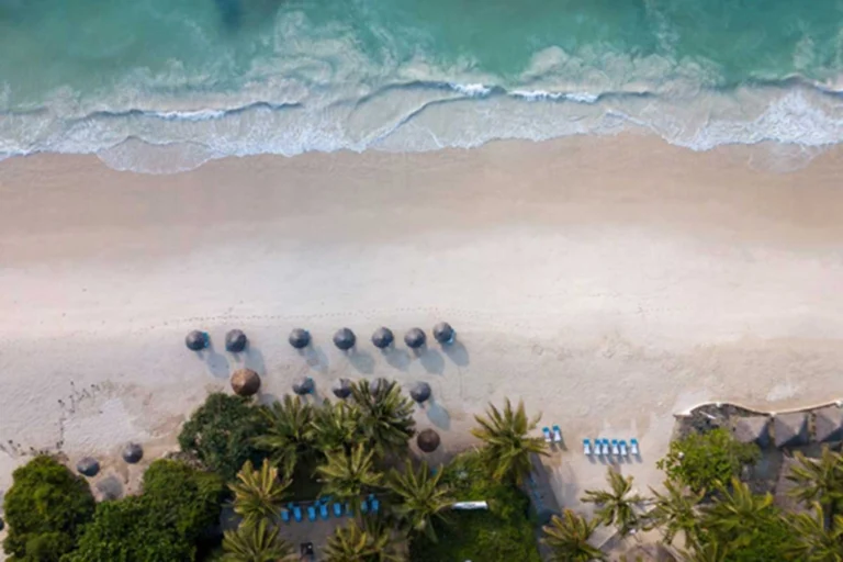 Aerial view of the beach and palm-lined resort edge at Diamonds Leisure Beach & Golf Resort