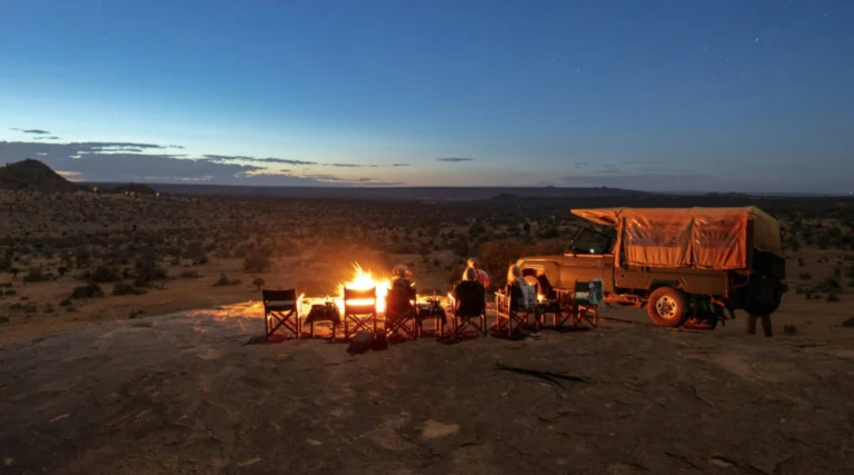 Safari vehicle beside an evening campfire in the Nanyuki area