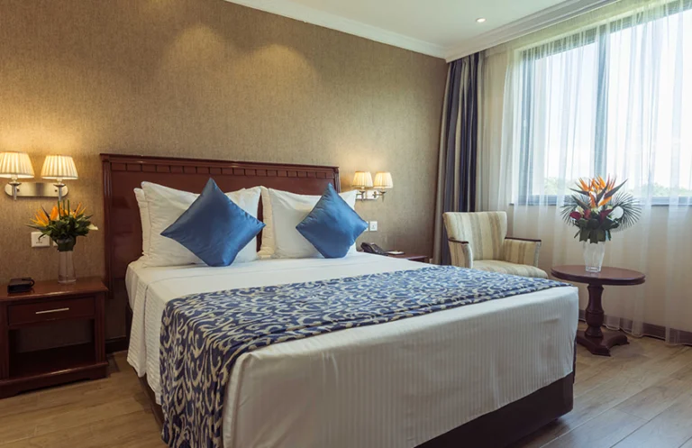 Guest room with blue cushions and a seating area at Sarova Woodlands Hotel & Spa