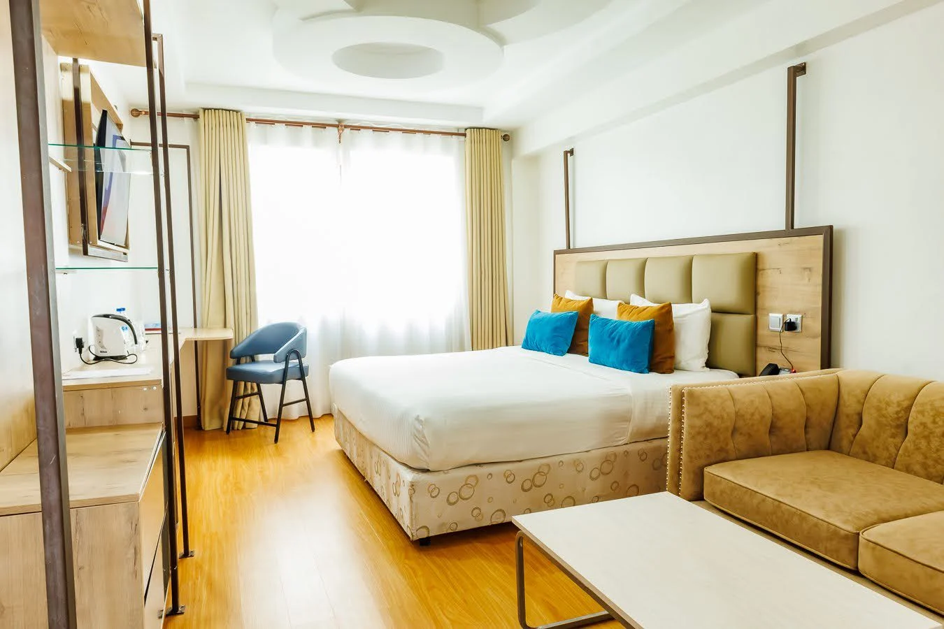 Modern guest room with turquoise cushions at The Warwick Hotel Nanyuki