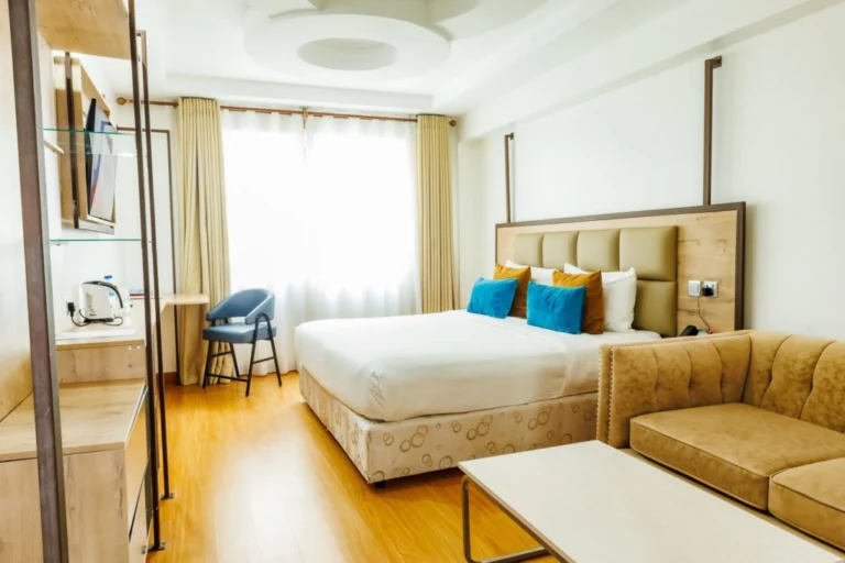 Modern guest room with turquoise cushions at The Warwick Hotel Nanyuki