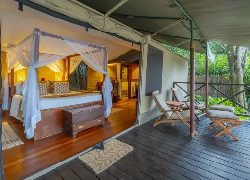 Safari tent with a furnished wooden deck at Mara Intrepids
