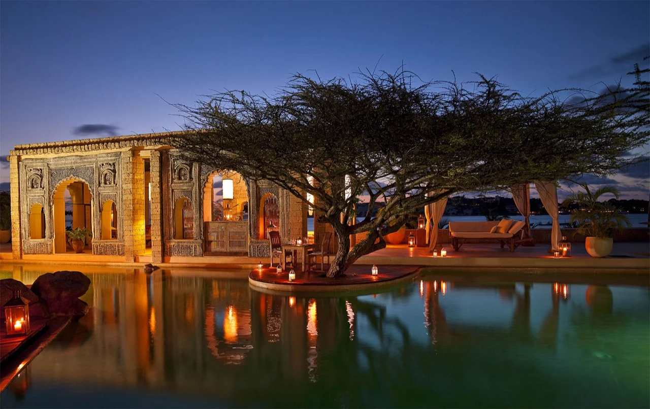 The Majlis villas glowing at dusk above the pool at The Majlis Resort